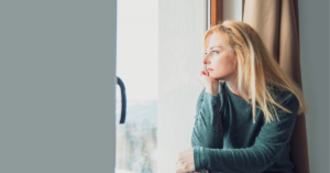 young woman looking out window getting ghosted